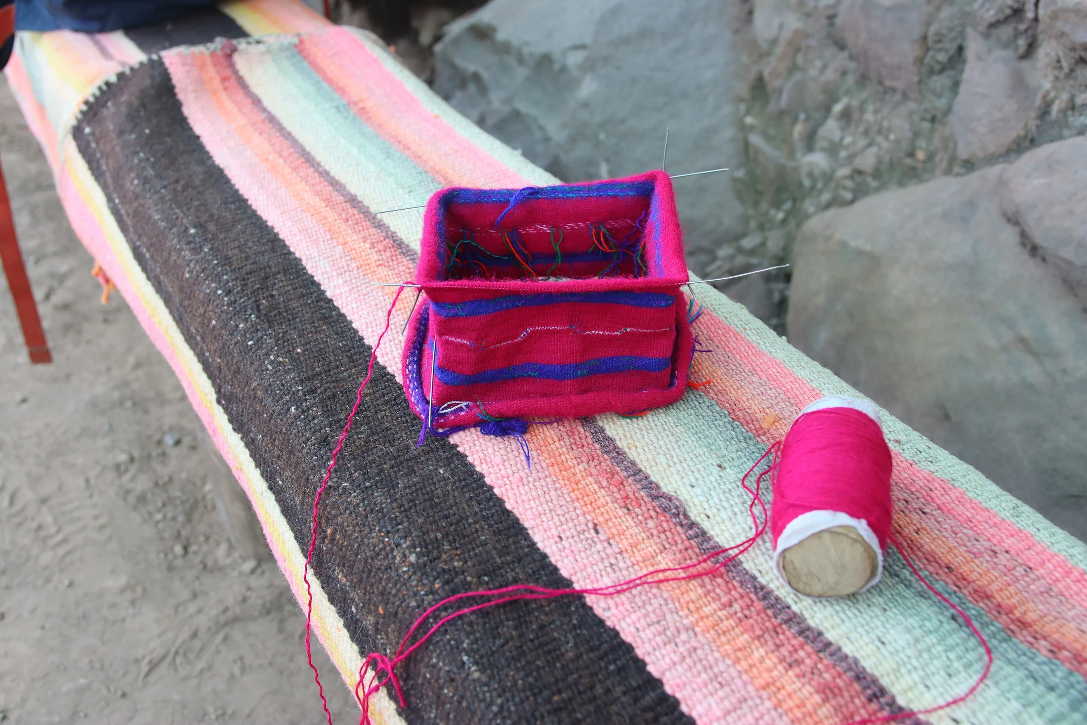 A knitted hat, woven bag, striped textile and red yarn on Taquile Island.