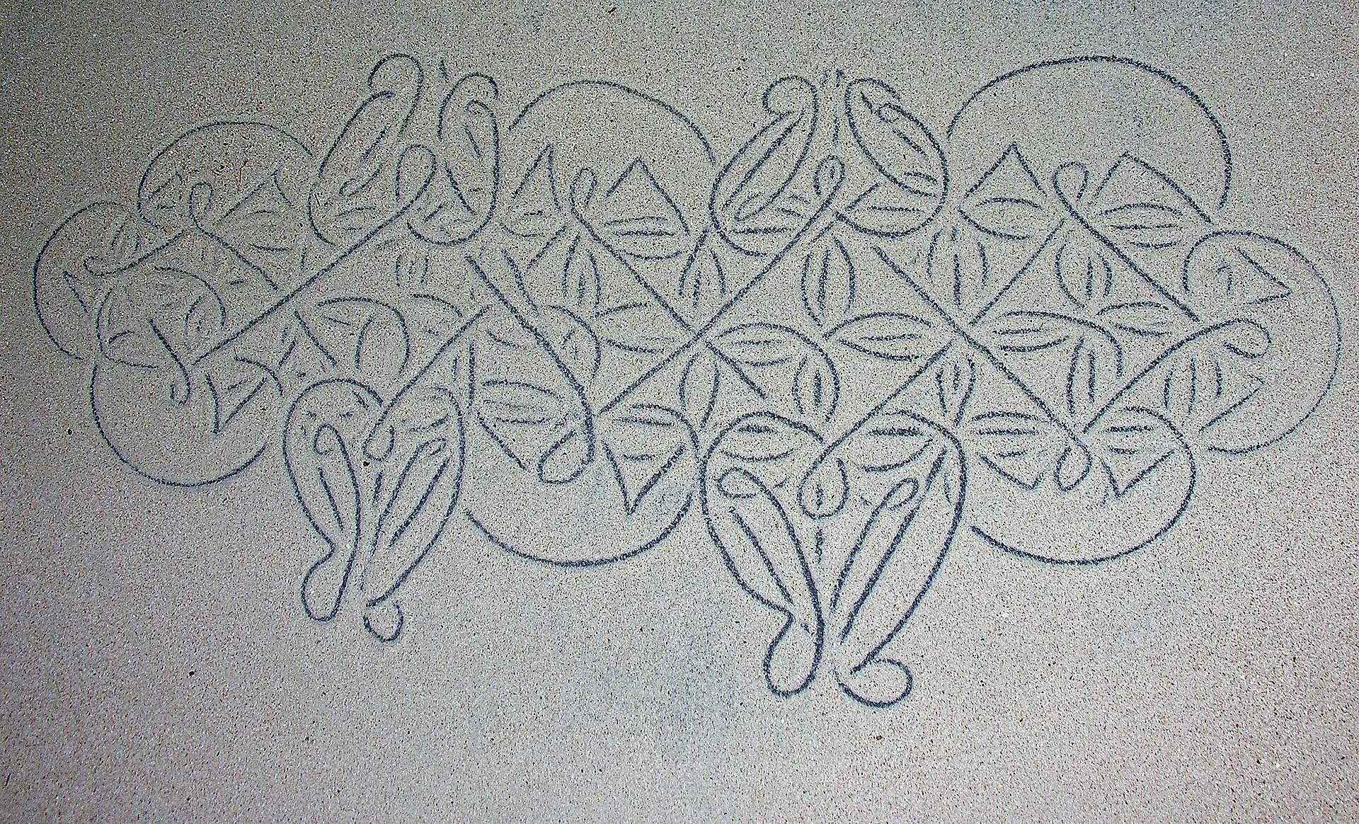 An intricate continuous geometric line drawn in sand in Vanuatu.